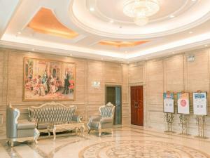 a lobby with chairs and a painting on the wall at Vienna Hotel Jian People Square in Ji'an