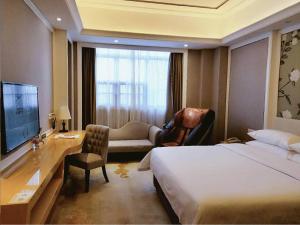 Pokój hotelowy z łóżkiem, biurkiem i telewizorem w obiekcie Vienna International Hotel Shenzhen Tian'an Digital City w mieście Longgang