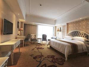 a large hotel room with a bed and a desk at Vienna International Hotel Jieyang People's Avenue in Jieyang