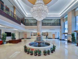 a large lobby with a fountain in the middle of a building at Vienna International Hotel Beijing GuangAnMen in Beijing