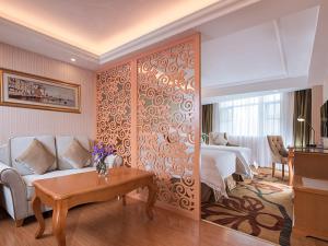 een slaapkamer met een bed, een bank en een tafel bij Vienna Hotel Guangzhou Tianhe Bus Station in Guangzhou