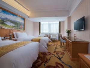 a hotel room with four beds and a flat screen tv at Vienna Hotel (Shengzhou Bada Hotel) in Shengzhou