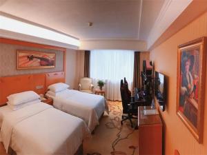 een hotelkamer met 2 bedden en een televisie bij Vienna Hotel Zhongshan Central Coach Station in Changzhou