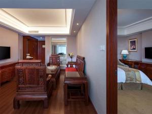 a room with a bedroom with a bed and a desk at Vienna International Hotel Shaoguan Fengcailou in Shaoguan +2 photos
