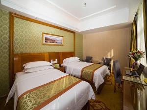 Кровать или кровати в номере Vienna Hotel Shandong Yantao Golden Beach Taishan Road