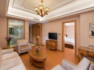 a living room with a couch and a room with a bed at Vienna Hotel Foshan Nanhai Avenue Branch in Foshan