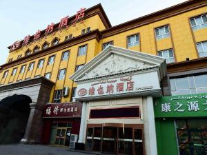 żółty budynek z napisem na górze w obiekcie Vienna Hotel Xinjiang Yining Shanghai City w Yining