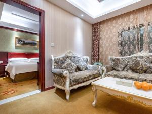 a living room with two couches and a bed at Vienna Hotel Shanghai Songjiang Wanda in Songjiang