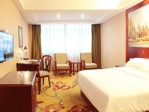 寧波市にあるVienna International Hotel Ningbo South Huancheng Roadのベッドとデスクが備わるホテルルームです。