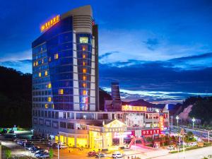 a tall building with a sign on top of it at Vienna Hotel Ganzhou Anyuan in Tieshan