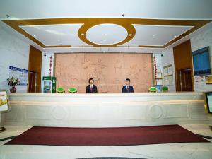 two men standing behind a counter in a lobby at Vienna Hotel Shandong Yantao Golden Beach Taishan Road in Yantai