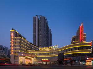 Vienna 3 Best Hotel Guangxi Nanning Station في نانينغ: مبنى كبير مع مبنيين طويلين في مدينة