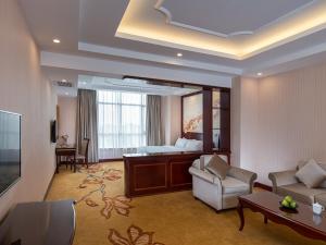 een hotelkamer met een bed en een woonkamer bij Vienna Hotel Dongguan Shi in Dongguan