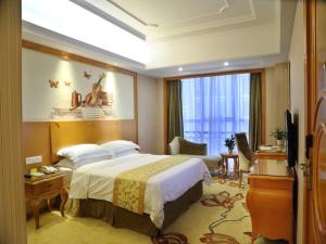 pokój hotelowy z łóżkiem i telewizorem w obiekcie Vienna International Hotel Changsha West Bus Station w mieście Changsha