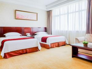 Habitación de hotel con 2 camas y sofá en Vienna Hotel Wuxi Wangzhuang Road, en Wuxi