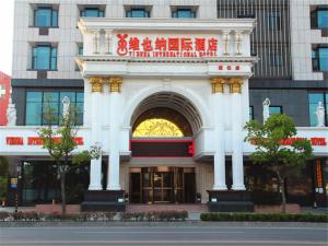 a white building with an arch in front of a building at Vienna International Hotel Shanghai Pujiang Town in Shanghai
