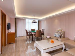 een woonkamer met een bank en een eetkamer bij Vienna Hotel Zhongshan Central Coach Station in Changzhou