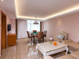 a living room with a couch and a dining room at Vienna Hotel Zhongshan Central Coach Station in Changzhou