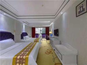 a large bedroom with two beds and a desk at Vienna Hotel Guilin Exposition Center in Guilin