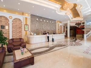 a woman standing in a lobby of a hotel at Vienna Hotel Foshan Nanhai Avenue Branch in Foshan