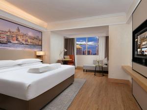 a hotel room with a bed and a flat screen tv at Vienna International Hotel Changsha Furong Plaza in Changsha