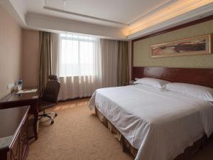 Un pat sau paturi într-o cameră la Vienna Hotel Shanghai Hongqiao Airport Center