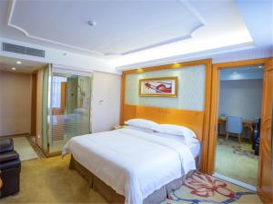 a bedroom with a large white bed in a room at Vienna Hotel Guangzhou Nanpu Station in Guangzhou