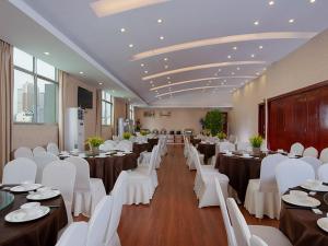 salę bankietową z białymi stołami i białymi krzesłami w obiekcie Vienna Hotel Nanning Changhu Road w mieście Nanning