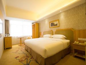 a bedroom with a large bed in a hotel room at Vienna 3 Best Hotel Huaian Qinghejiayuan in Huai'an