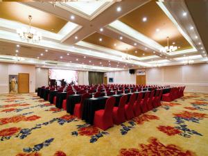 a conference room with red chairs and a large rug at Vienna Hotel Qinzhou North Area Plaza in Qinzhou +5 photos
