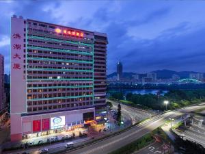 een gebouw met een bord bovenop een snelweg bij Vienna Hotel Shenzhen Honghu in Shenzhen