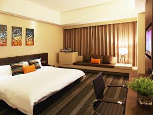 a bedroom with a bed and a table and a chair at Vienna International Hotel Changzhou Railway Station in Changzhou