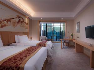 Vienna Hotel (Qionghai Yinhai Road) في Qionghai: غرفه فندقيه سريرين وتلفزيون