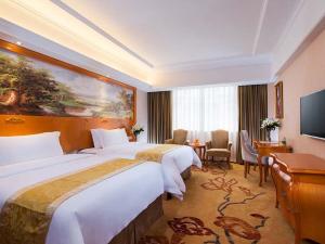 Habitación de hotel con 2 camas y TV de pantalla plana. en Vienna Hotel Changde Wuling Avenue, en Changde