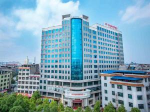 un edificio alto con ventanas azules en una ciudad en Vienna Hotel Hunan Shaodong Jinlong Ave, en Shaodong