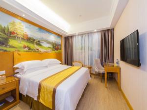 Habitación de hotel con cama y TV de pantalla plana. en Vienna 3 Best Hotel Fuzhou Fuma Road Ziyang en Fuzhou