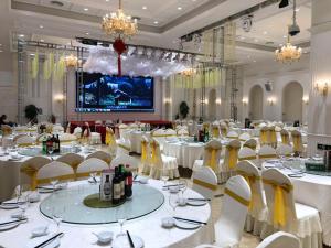 松江区にあるVienna Hotel Shanghai Songjiang Development Zoneの白いテーブルと白い椅子が備わる宴会場