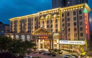 a large building with cars parked in a parking lot at Vienna Hotel Nanyang People Road in Nanyang