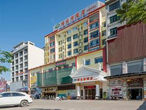 ein Gebäude mit einem davor geparkt in der Unterkunft Vienna Hotel (Qionghai Yinhai Road) in Qionghai