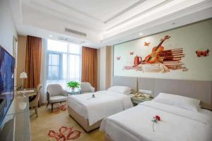 a hotel room with two beds and a tv at Vienna Hotel Nanyang People Road in Nanyang