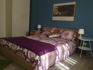 ein Schlafzimmer mit einem Bett mit einer lila Bettdecke in der Unterkunft Casa Di Amici in Caltanissetta