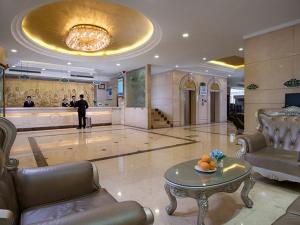 a lobby with a table and a man standing in a building at Vienna Hotel Nanchang Railway Staion in Nanchang