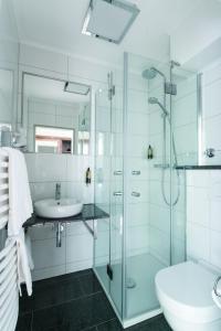 a bathroom with a glass shower and a sink at Hotel am Herkules in Kassel