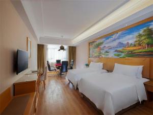 ein Hotelzimmer mit 2 Betten und einem Flachbild-TV in der Unterkunft Vienna Hotel Huiyang Sanhe Square in Huizhou