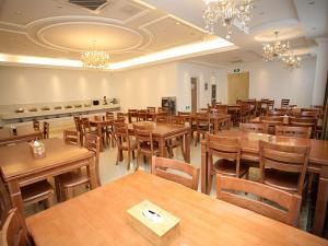 an empty restaurant with wooden tables and chairs at Vienna Hotel Jiangsu Kunshan Exhibition Center in Kunshan