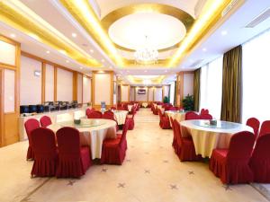Vienna International Hotel Changsha Ziwei Road في تشانغشا: قاعة احتفالات بها طاولات وكراسي وثريا