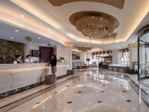 a lobby of a hotel with people standing at a counter at Vienna International Hotel Changzhou Hutang in Changzhou