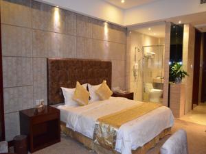a bedroom with a large bed and a bathroom at Vienna Hotel Dongguan Tangxia Guanlan Lake Golf Club in Dongguan