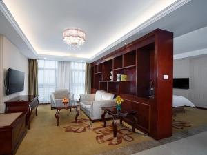 een grote woonkamer met een bank en een bed bij Vienna Hotel Chongqing Chuangyi Park in Shiping