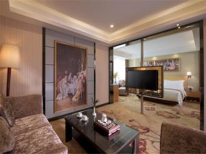 Sala de estar amplia con cama y TV en Vienna Hotel Dongguan ChangAn Wanda Plaza, en Dongguan